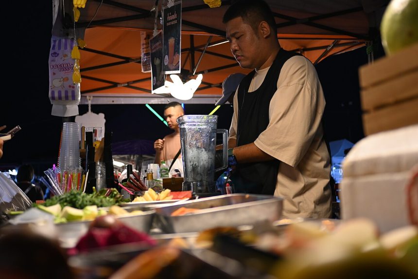 A vendor preparing fresh fruit drinks at a market stall