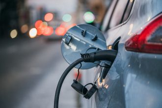 Close-up of an electric car plugged in and charging at the roadside