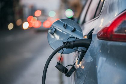 Close-up of an electric car plugged in and charging at the roadside