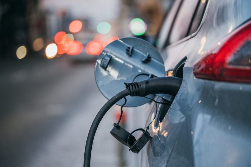 Close-up of an electric car plugged in and charging at the roadside
