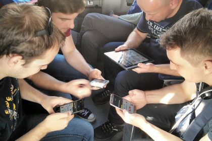 Friends playing a multiplayer mobile game together on their phones