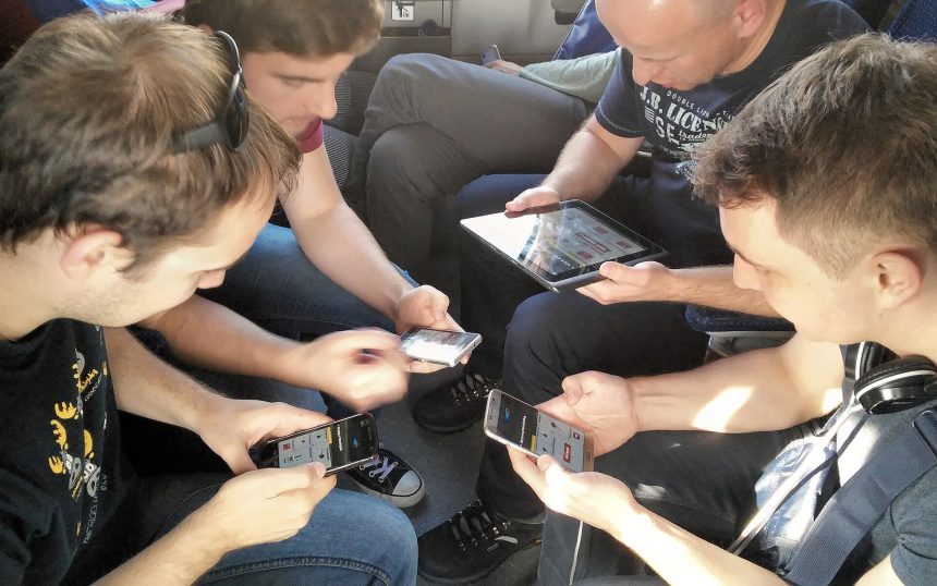 Friends playing a multiplayer mobile game together on their phones