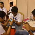 Students playing a mobile game together outdoors