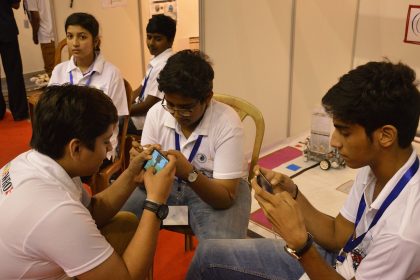Students playing a mobile game together outdoors