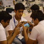 Students playing a mobile game together on a smartphone