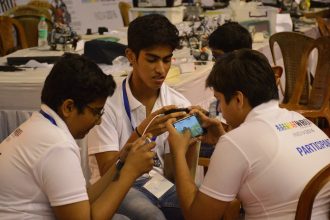 Students playing a mobile game together on a smartphone