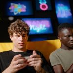 Two friends playing mobile games on smartphones