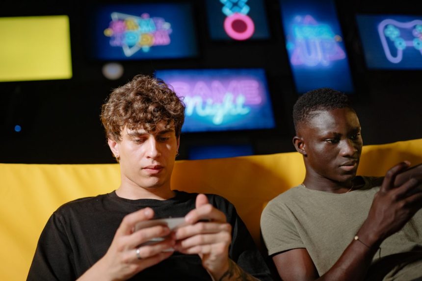 Two friends playing mobile games on smartphones