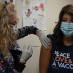 Healthcare worker preparing a measles vaccine dose at a clinic