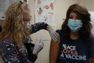 Healthcare worker preparing a measles vaccine dose at a clinic